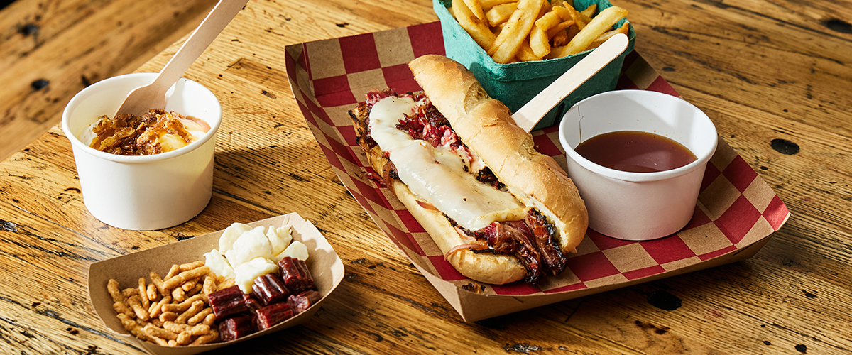 Sandwich and fries on a checkered napkin and wood table